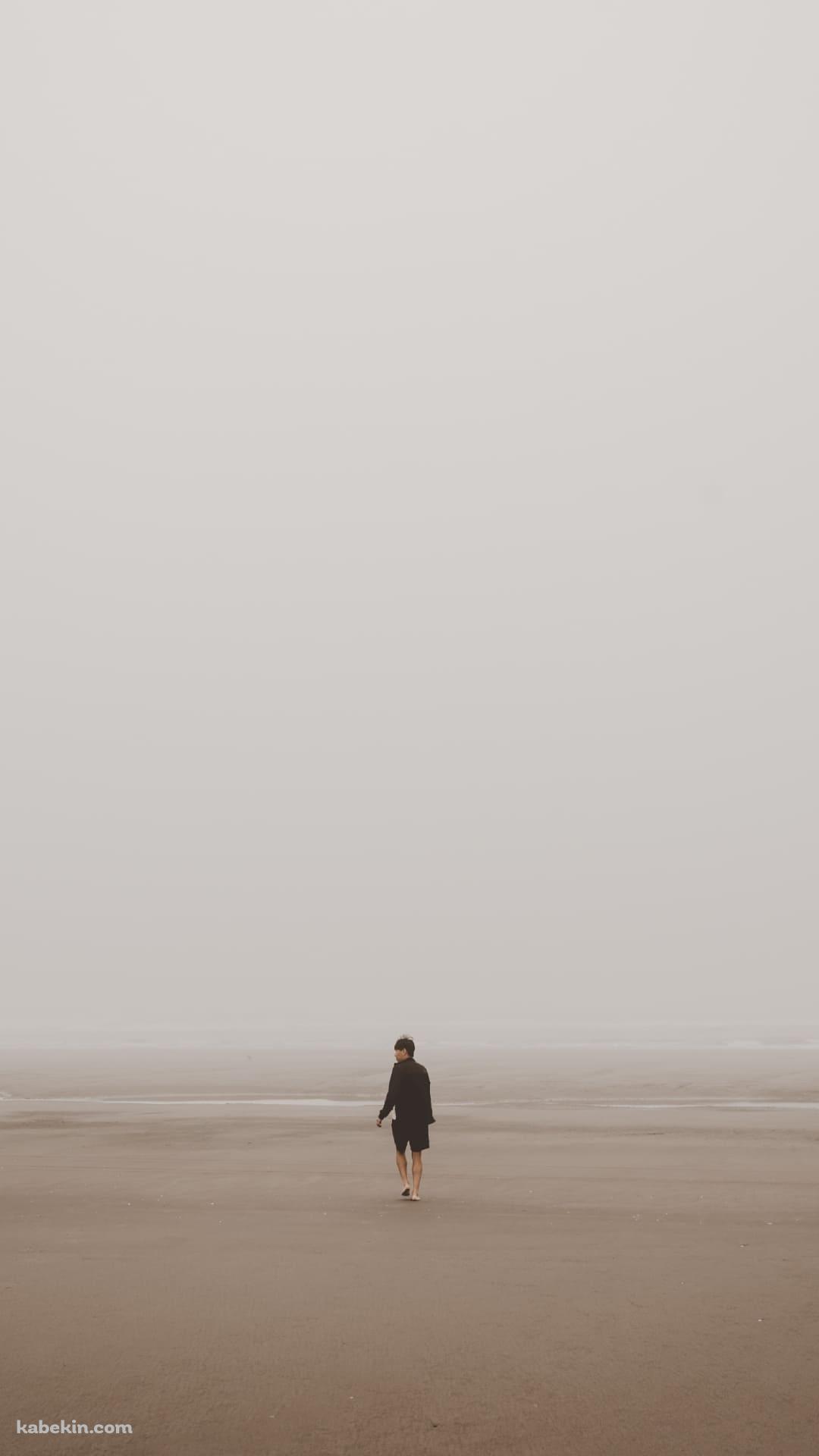 海辺 砂浜を歩く男性のAndroidの壁紙(1080px x 1920px) スマホ用