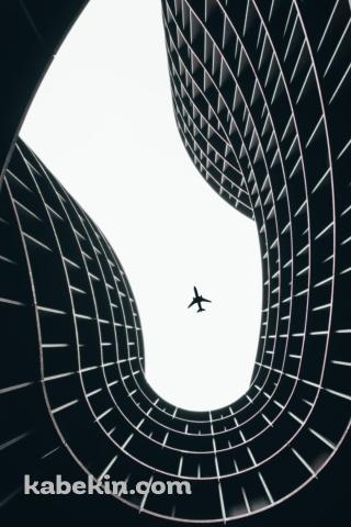 見上げた黒いデザイナーズマンションと飛行機のAndroidの壁紙(320px x 480px) スマホ用