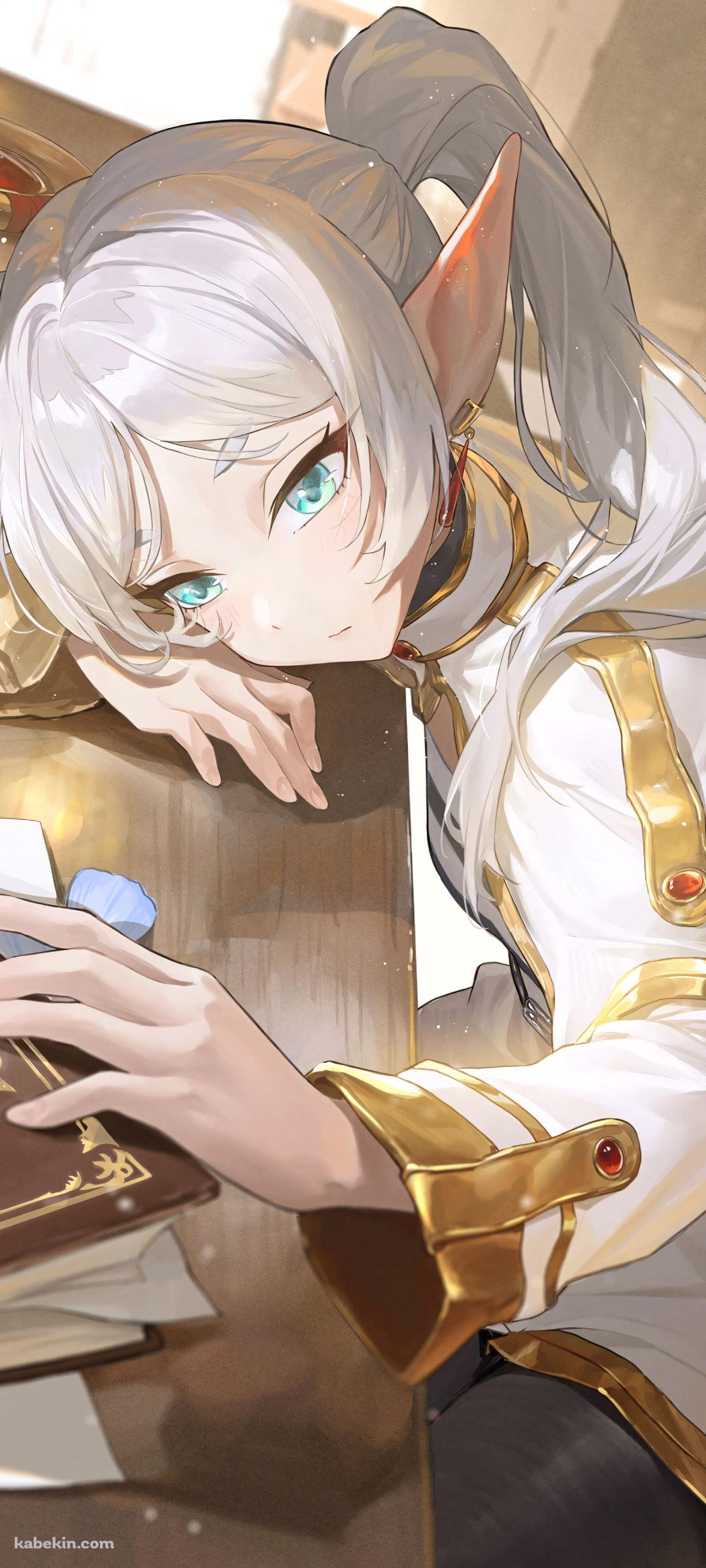 テーブルにうつ伏せになり本に触るフリーレン / 葬送のフリーレンのAndroidの壁紙(1080px x 2400px) スマホ用