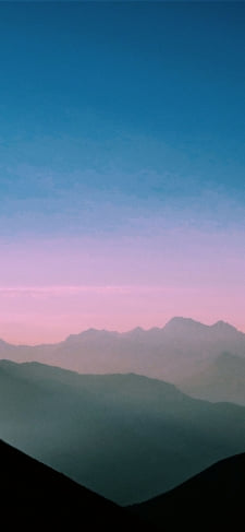 青いグラデーションの空と霞んで見える山のiPhone / スマホ壁紙