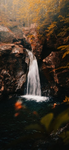紅葉と岸壁から落ちる小さい滝のiPhone / スマホ壁紙