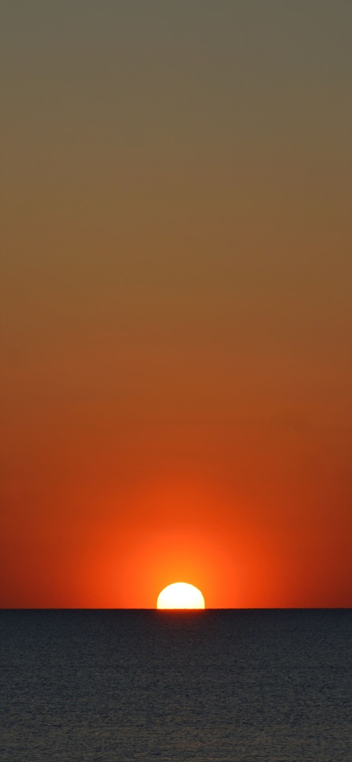 オレンジの夕日と漆黒の海の1170 x 2532 / スマホ壁紙
