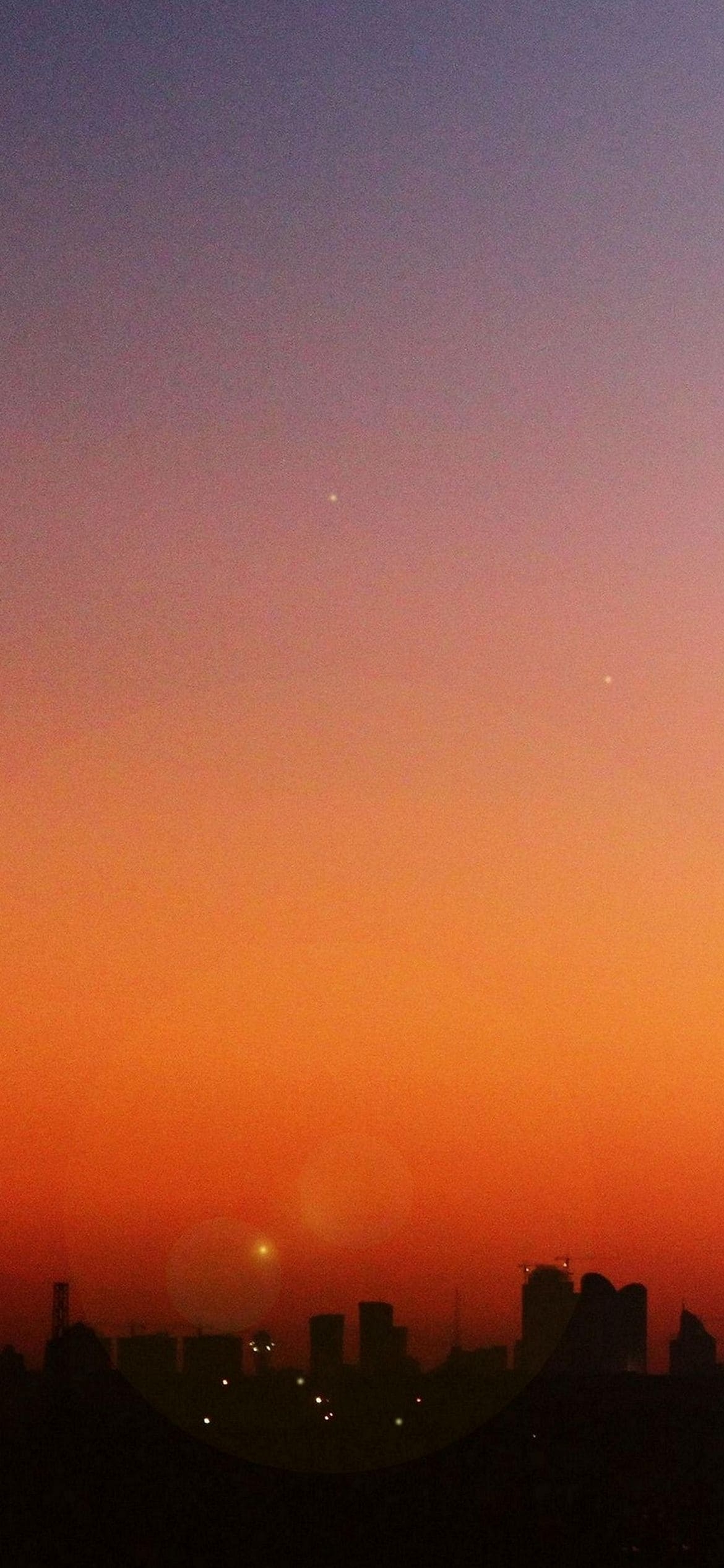 オレンジ色の綺麗な夕日とビルの影の1170 x 2532 / スマホ壁紙