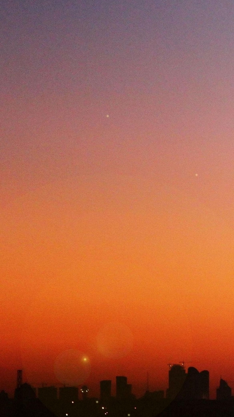 オレンジ色の綺麗な夕日とビルの影の750 x 1334 / スマホ壁紙