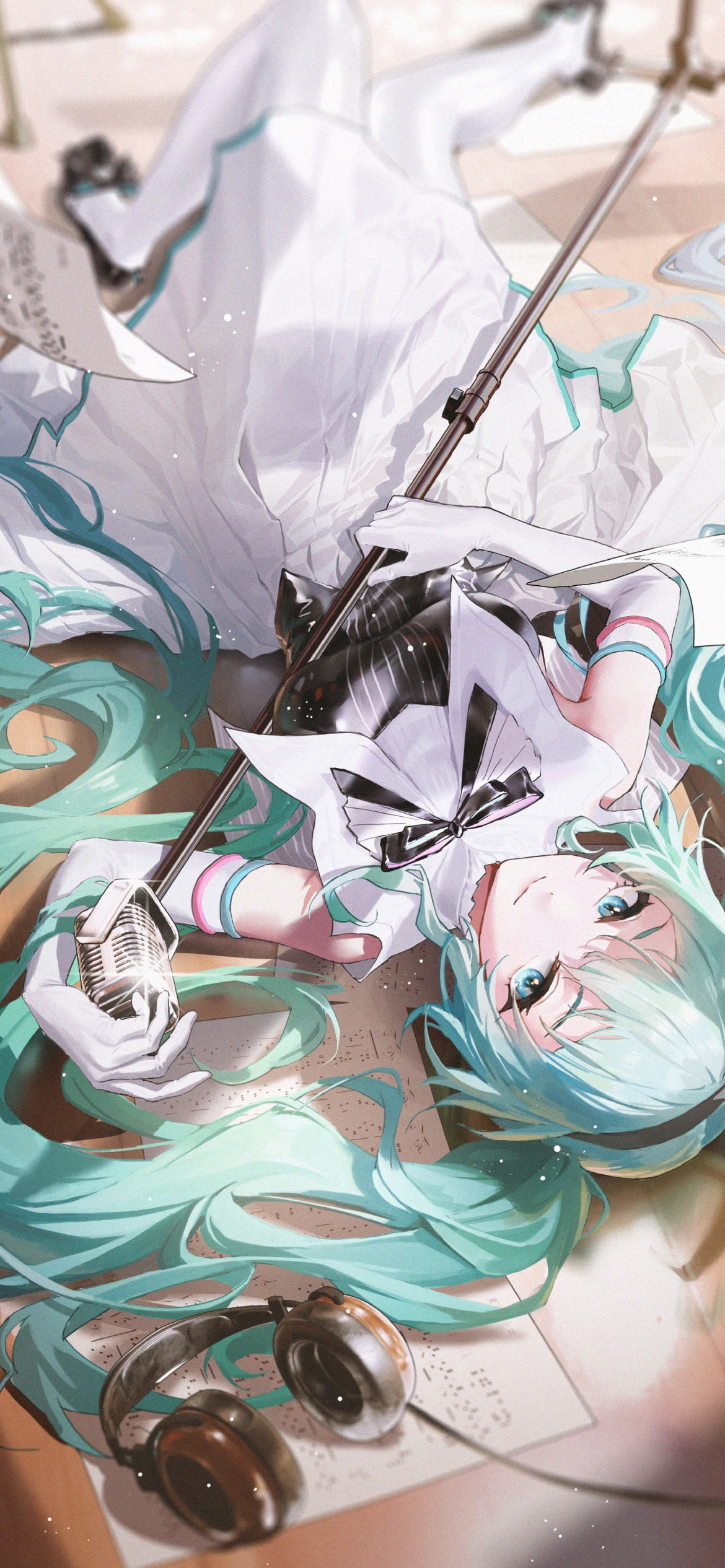フローリングに寝てマイクスタンドを持っている可愛い初音ミク / ボカロ / ボーカロイドの1170 x 2532 / スマホ壁紙