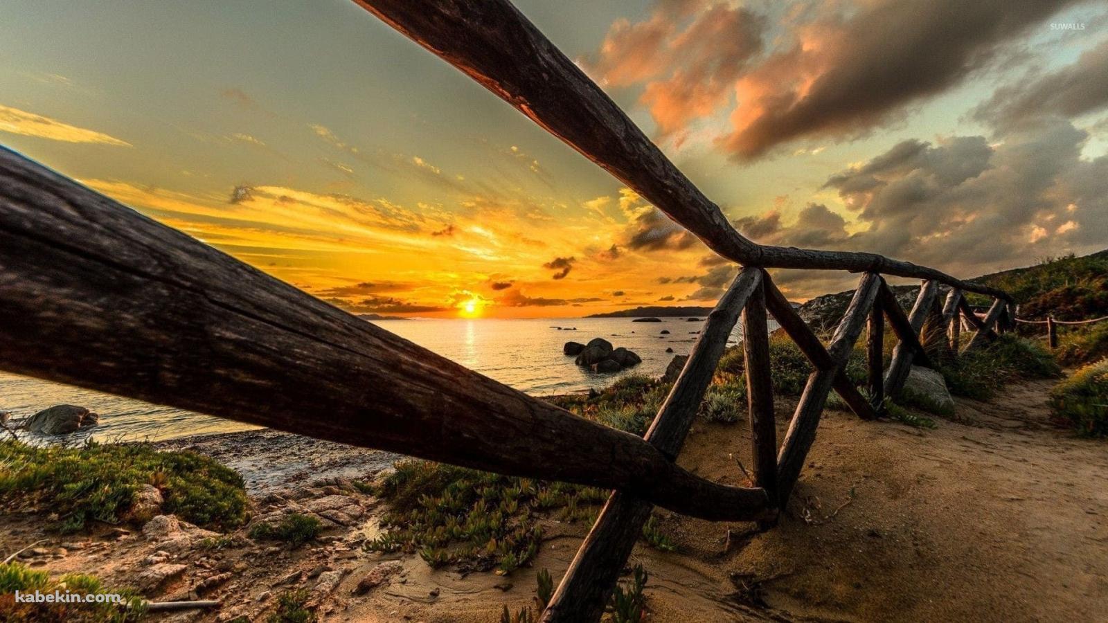 木のフェンス越しに見える綺麗な海と夕陽の壁紙(1600px x 900px) 高画質 PC・デスクトップ用
