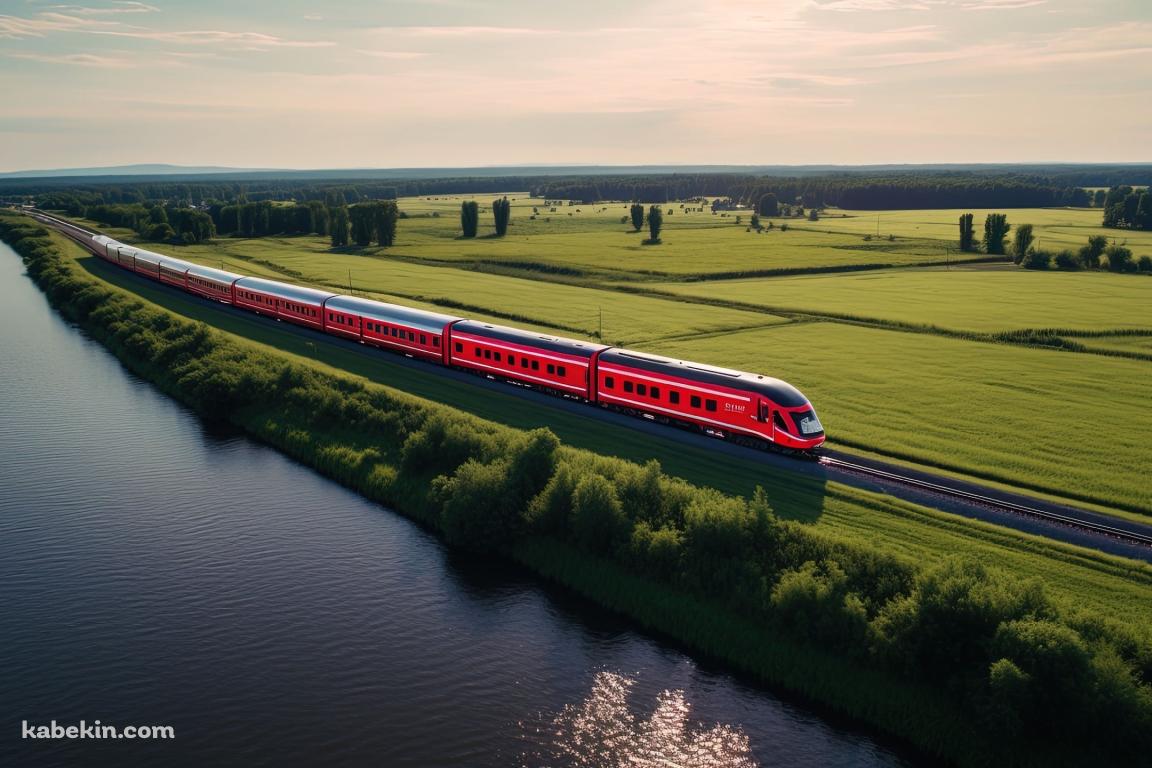 川沿いの線路を走る鮮やかな赤い電車の壁紙(1152px x 768px) 高画質 PC・デスクトップ用