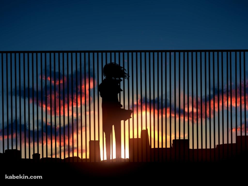 ビルの屋上の柵越しから夕陽を眺める女性の壁紙(1024px x 768px) 高画質 PC・デスクトップ用