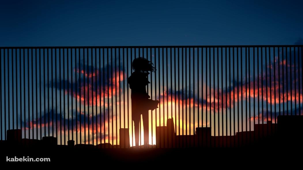 ビルの屋上の柵越しから夕陽を眺める女性の壁紙(1051px x 591px) 高画質 PC・デスクトップ用