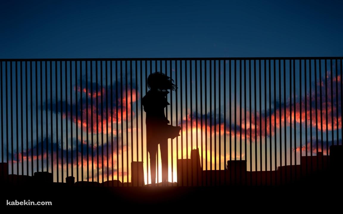ビルの屋上の柵越しから夕陽を眺める女性の壁紙(1152px x 720px) 高画質 PC・デスクトップ用
