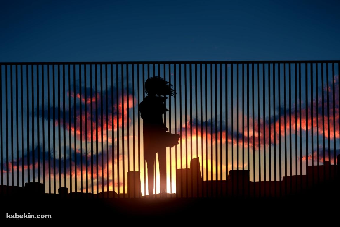 ビルの屋上の柵越しから夕陽を眺める女性の壁紙(1152px x 768px) 高画質 PC・デスクトップ用