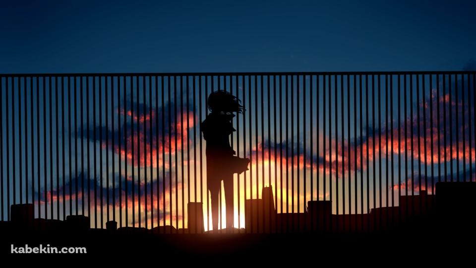 ビルの屋上の柵越しから夕陽を眺める女性の壁紙(960px x 540px) 高画質 PC・デスクトップ用