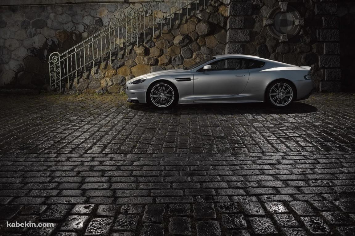 濡れた石畳の道路と停車中のシルバーのアストンマーチンの壁紙(1152px x 768px) 高画質 PC・デスクトップ用
