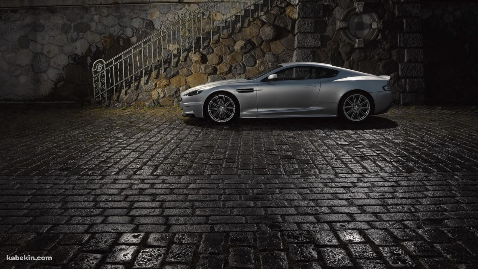 濡れた石畳の道路と停車中のシルバーのアストンマーチンの壁紙(1600px x 900px) 高画質 PC・デスクトップ用