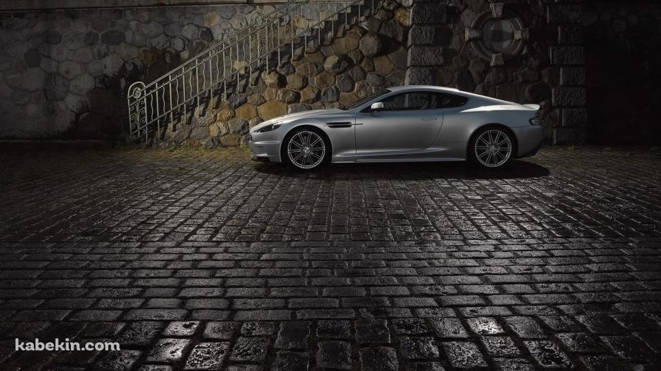 濡れた石畳の道路と停車中のシルバーのアストンマーチンの壁紙(960px x 540px) 高画質 PC・デスクトップ用