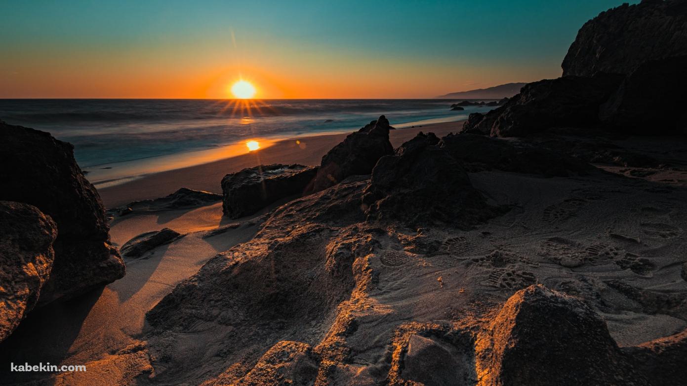 海岸の砂浜から見る夕陽と海の壁紙(1391px x 783px) 高画質 PC・デスクトップ用